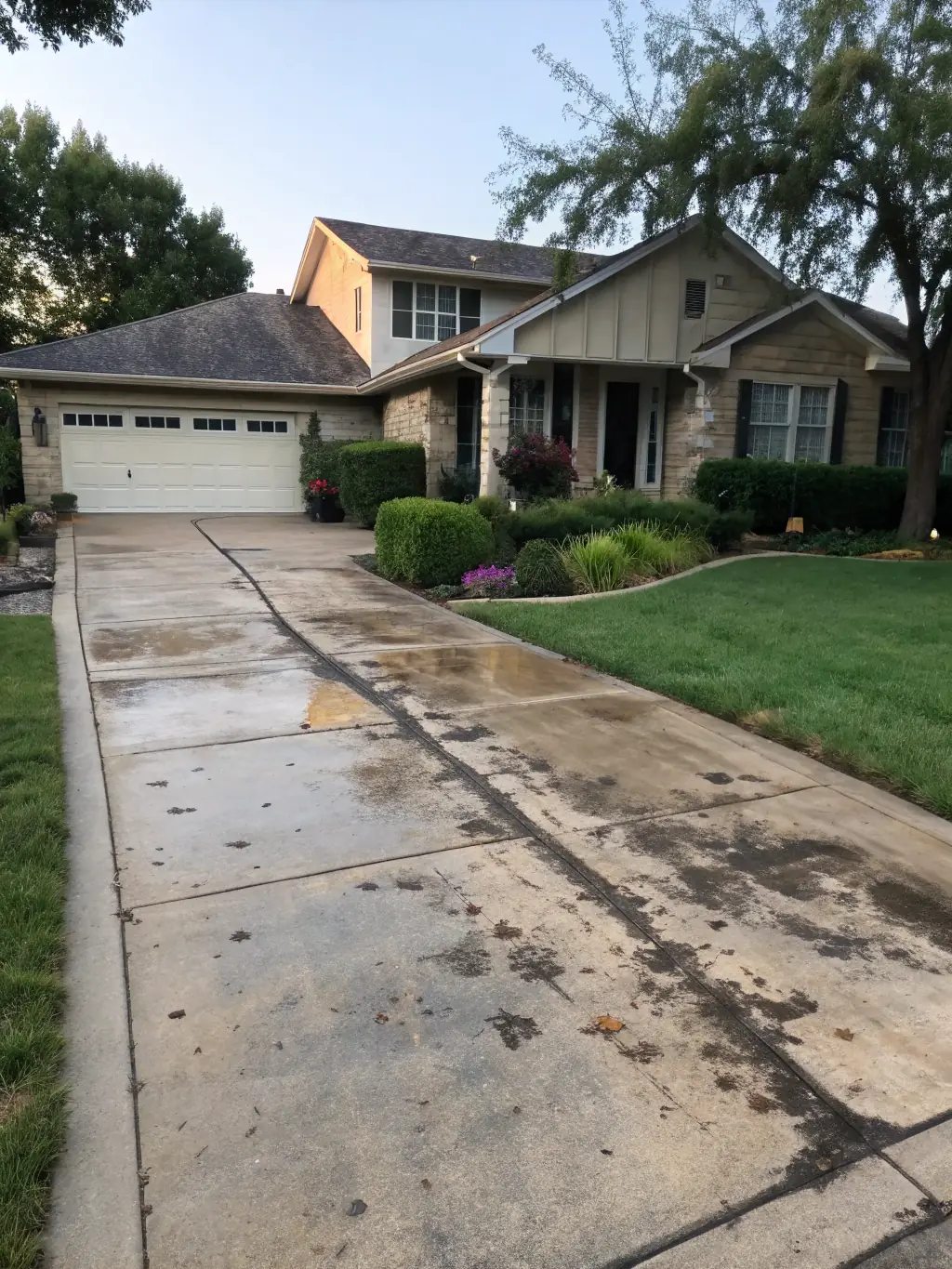A clean driveway and siding after power washing, showcasing a bright and refreshed home exterior.
